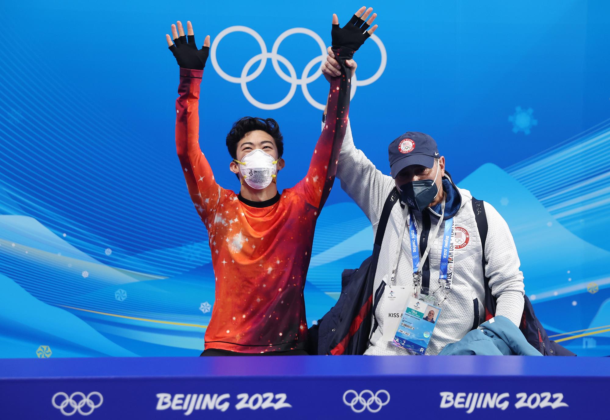 Rafael Arutyunyan holds up Nathan Chen's arm to show he had won gold at the Beijing Olympic Winter Games.