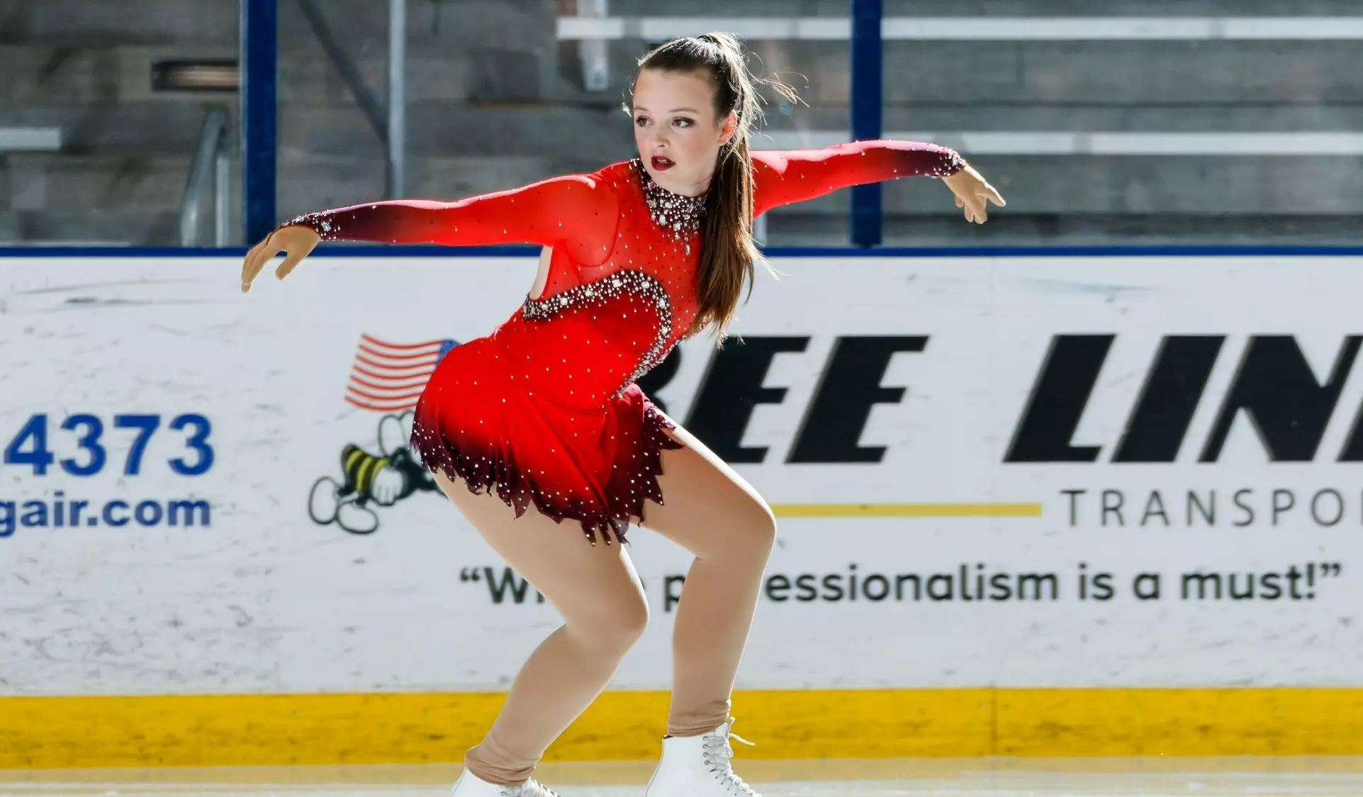 Angela Bosher in a bright red skates backward.