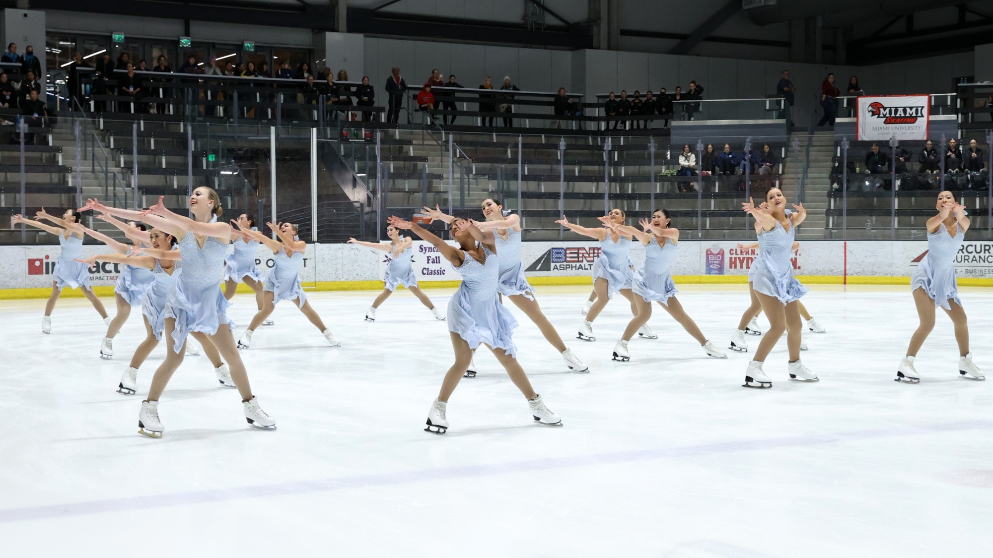 DC EDGE, in light blue dresses, reach to the left as part of their choreography.