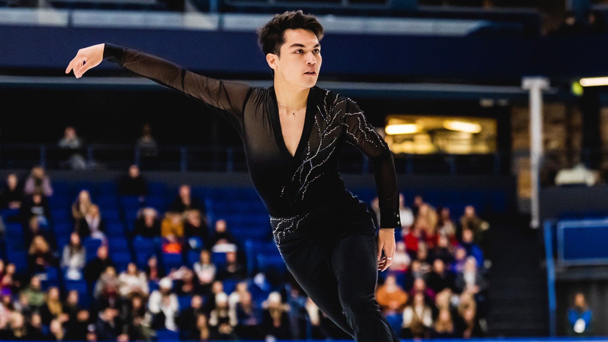 Camden Pulkinen, dressed in all black, skates gracefully on the ice at Grand Prix Espoo.