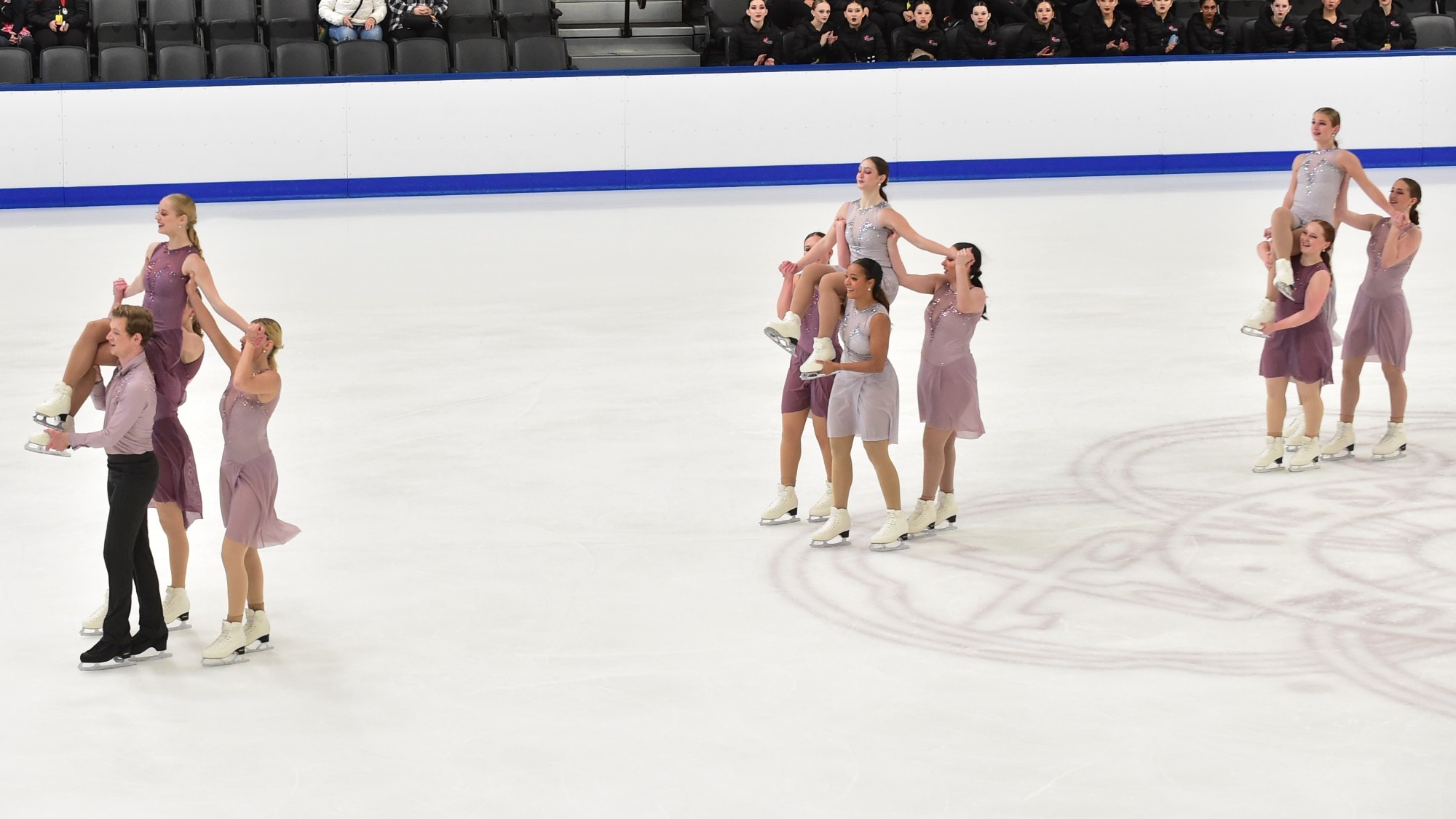 Hayden Select performs a lift with three sets of athletes with one sitting on each other's shoulders.