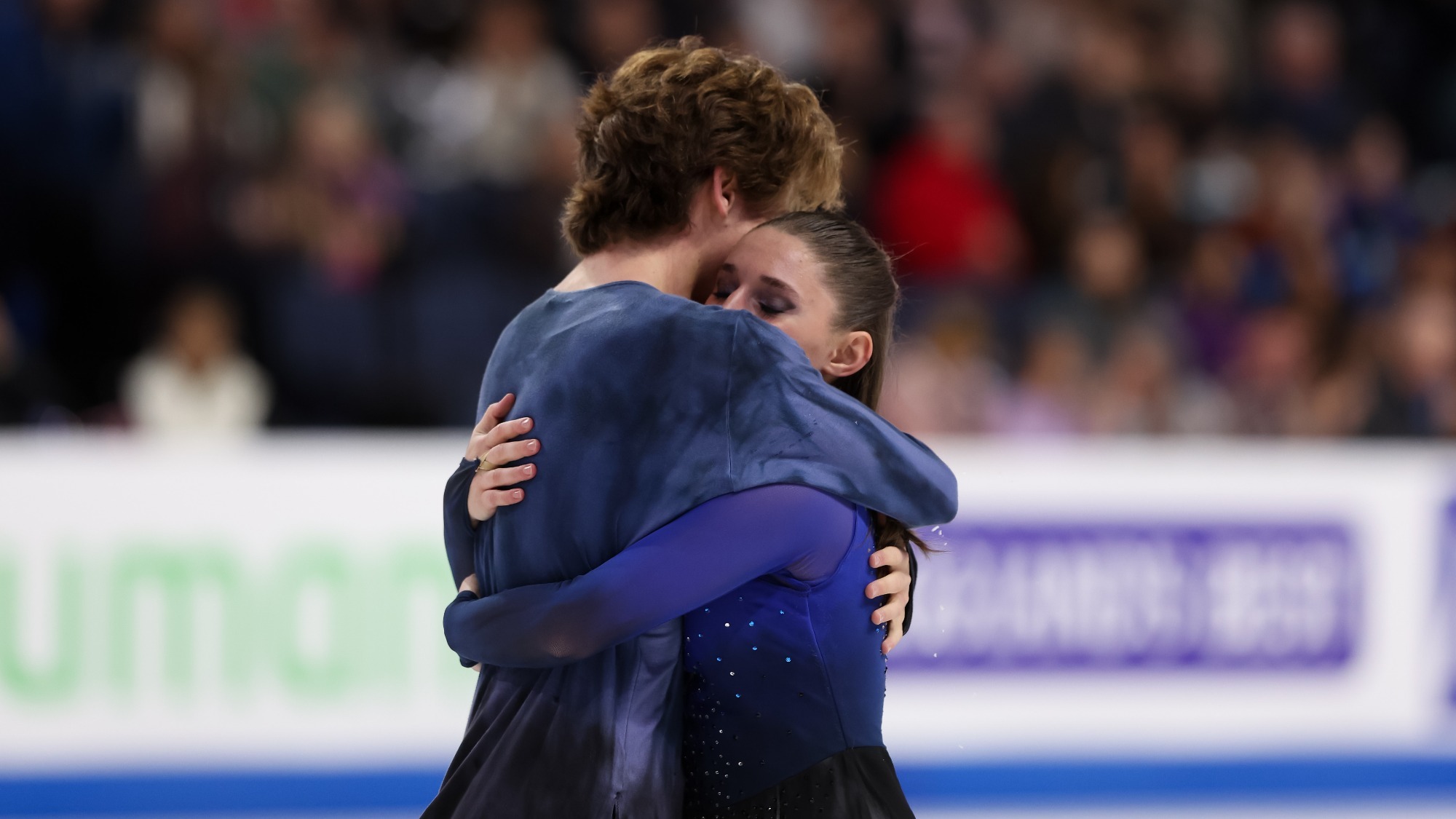 Taken from the waist up, Oona Brown and Gage Brown hug after their free skate at Skate America.