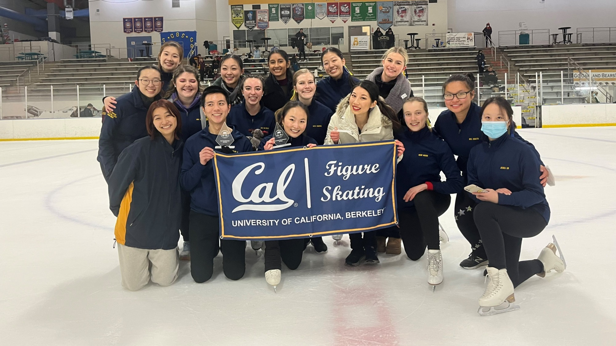 Group photo of the Cal Berkley Figure Skating Team holding a banner with the team name on it. 