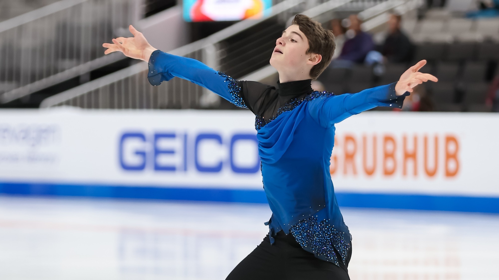 Lucas Broussard during his free skate, his arms out wide.