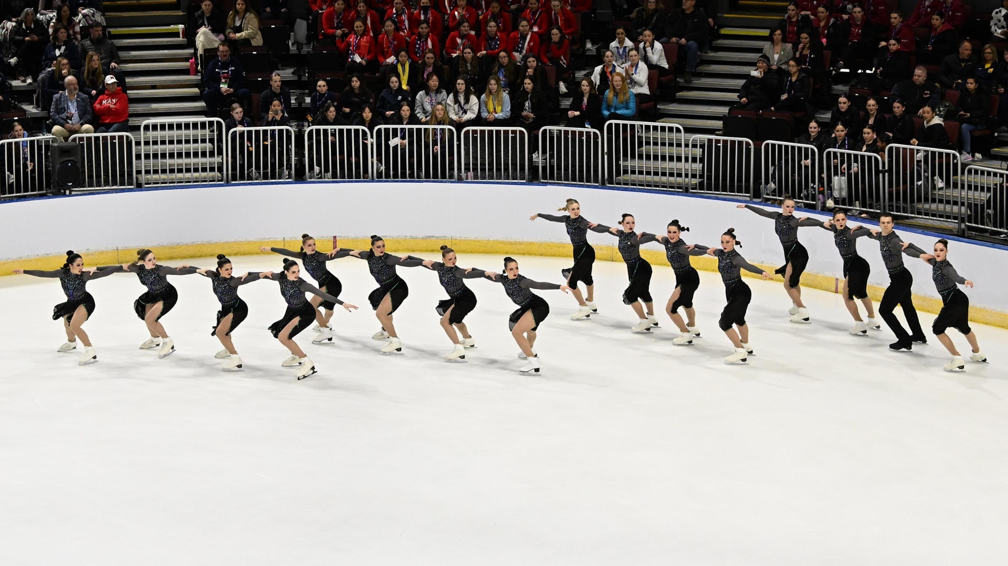 The Haydenettes skate in four parallel lines near the right-side rinkboards during their free skate at the 2023 U.S. Synchronized Skating Championships.