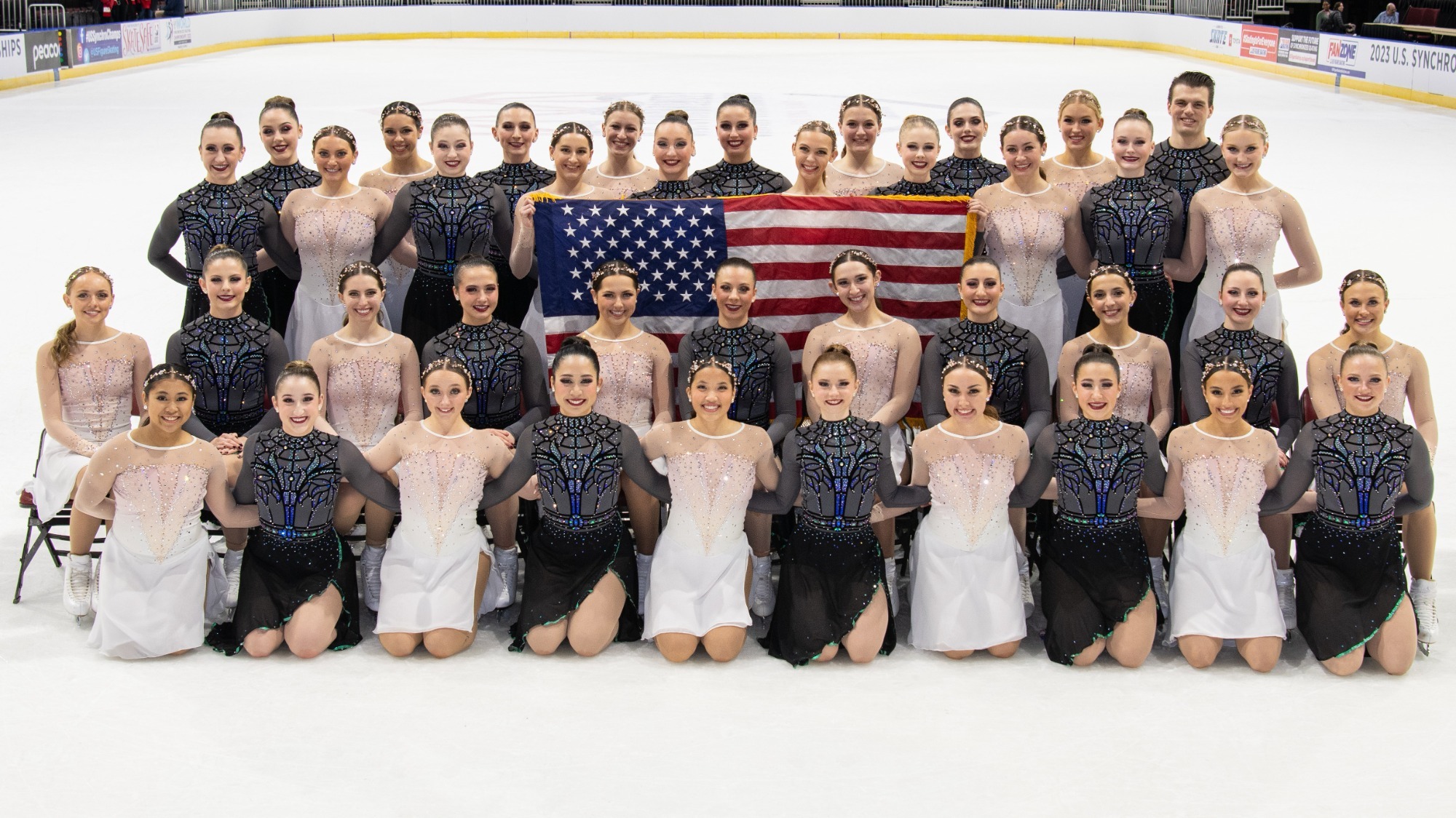 The Haydenettes and Miami University, who were both named to the World Team, are intermixed and pose for a photo with the USA flag.