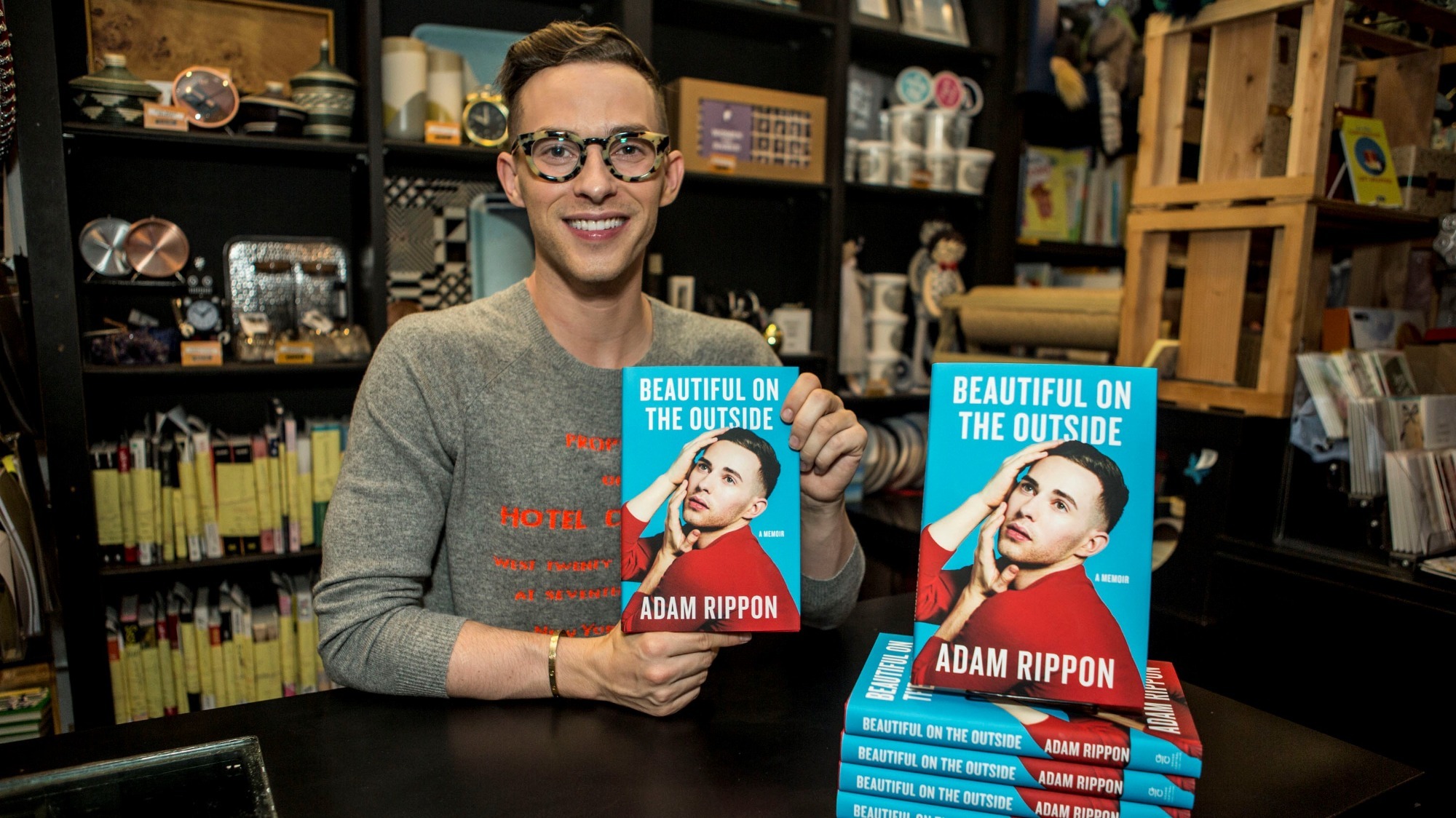 Adam Rippon poses with a copy of his book 