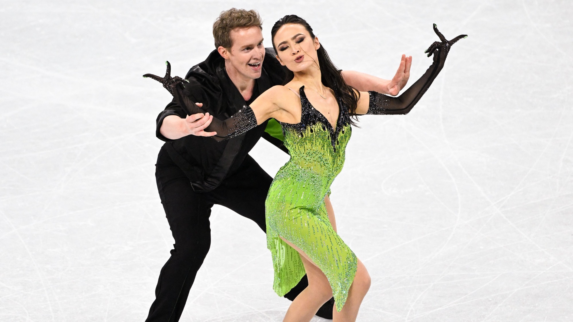 Madison Chock and Evan Bates begin their Billie Eilish short program from the 2021-22 season. Evan stands behind Madison looking excited, while Madison plays the villain.