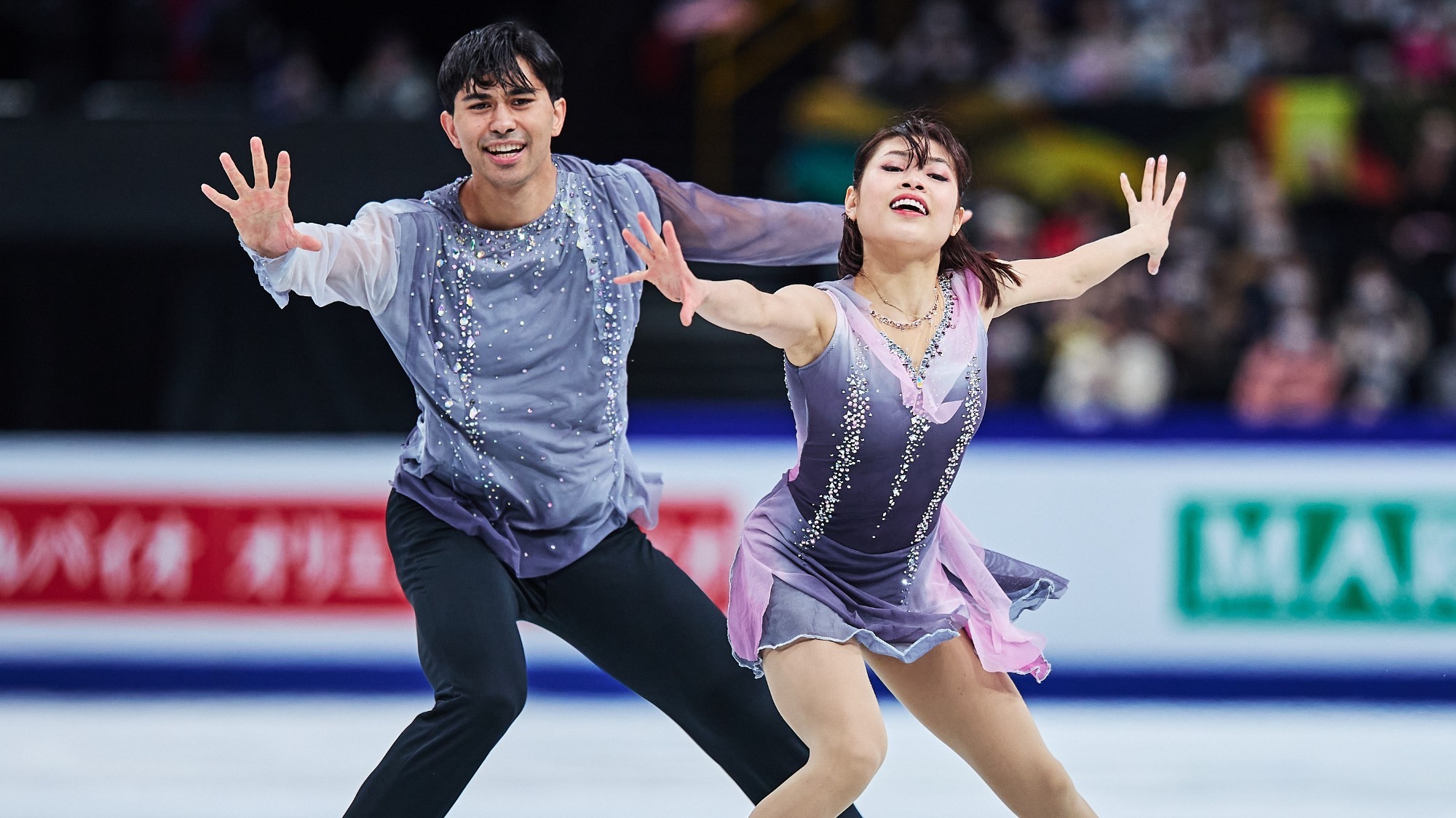 Emily Chan  and Spencer Howe reach toward the camera with strong emotion with Emily slightly in front of Spencer.
