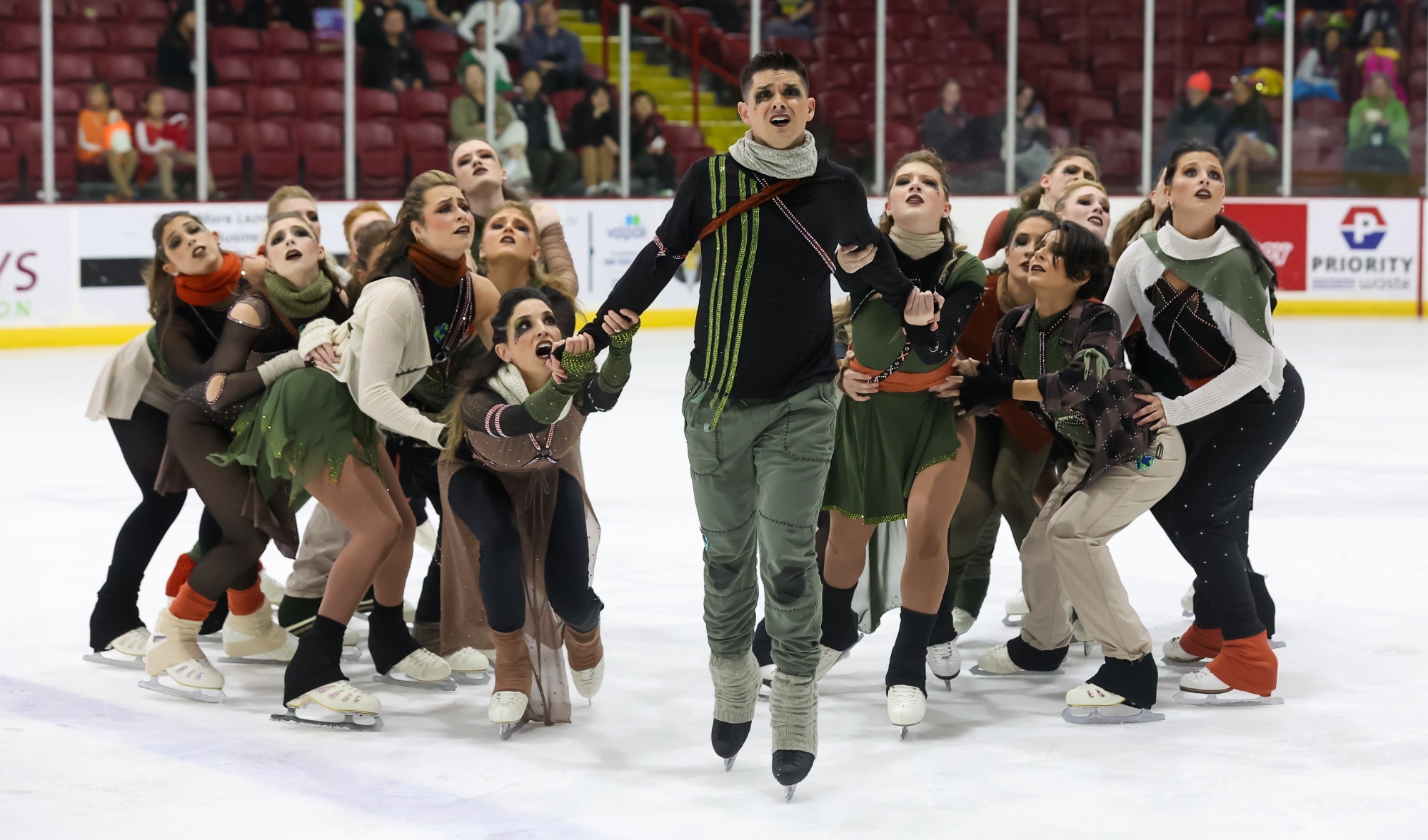 Harmony performs their free performance wearing brown and green colored costumes. 
