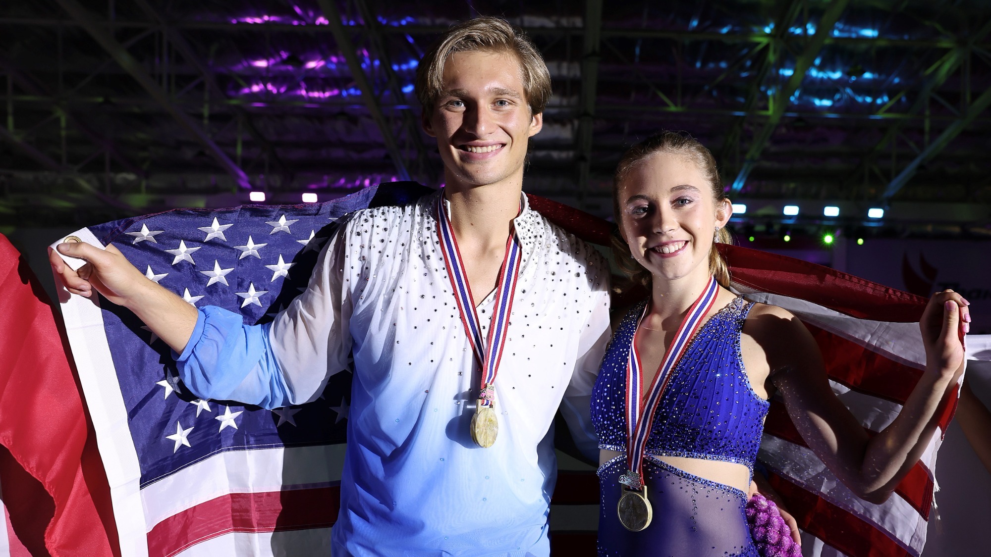 Gold medalists Leah Neset and Artem Markelov of United States pose at the medal ceremony holding the U.S. flag behind them at the ISU Junior Grand Prix of Figure Skating Bangkok 2023 in Bangkok, Thailand. 