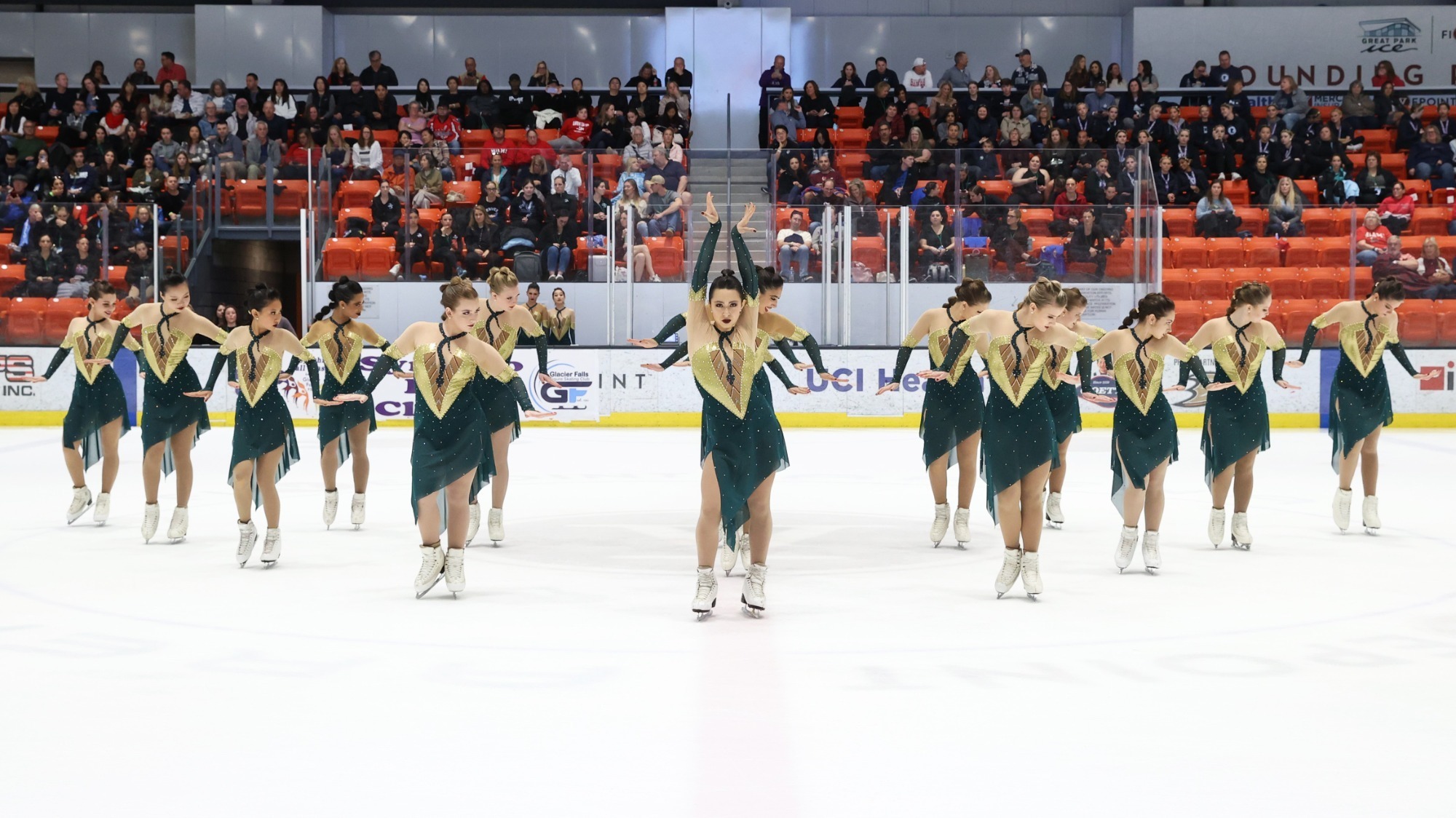 Teams Elite performs their skate charmer-themed free skate in matching green and gold skating costumes at Budapest Cup 2024. 