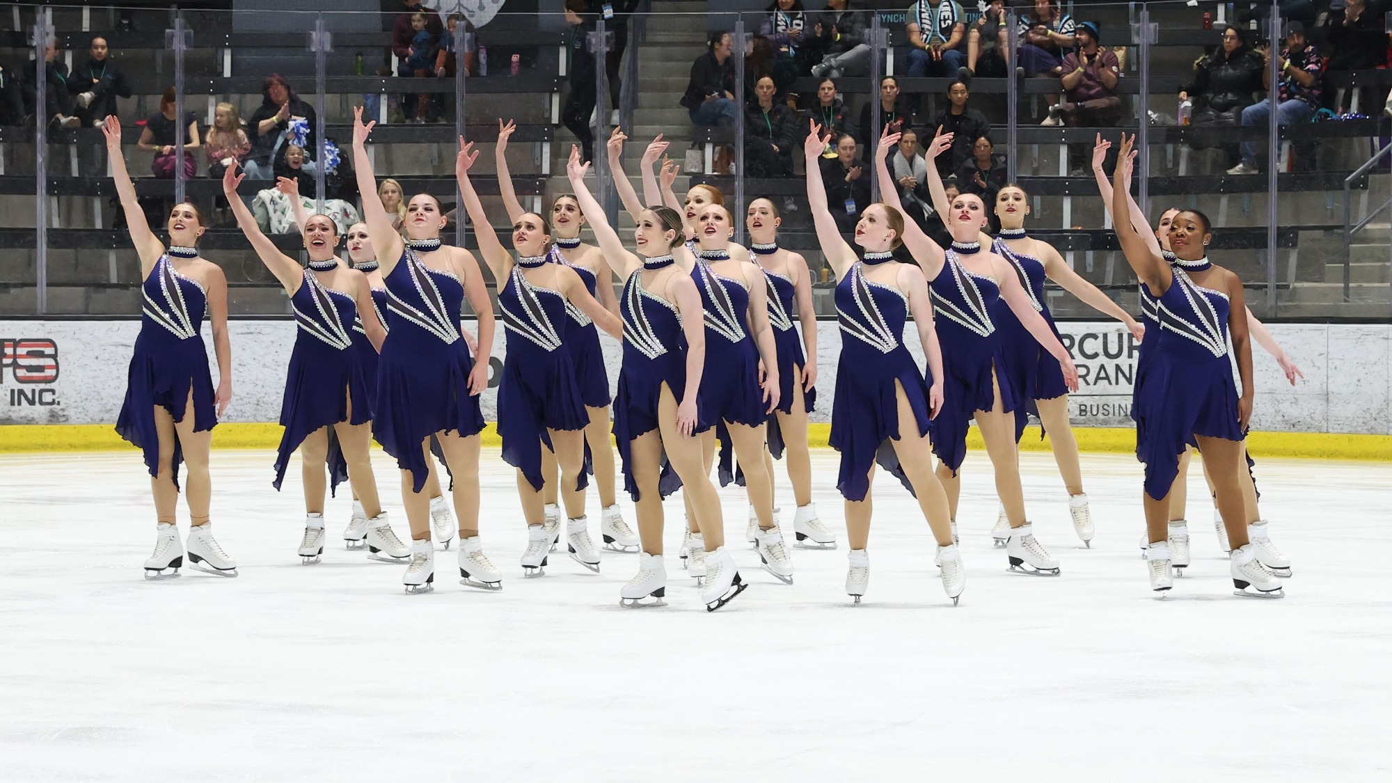 The Skyliners in purple dresses, stand together with each holding their right arm up in the air.
