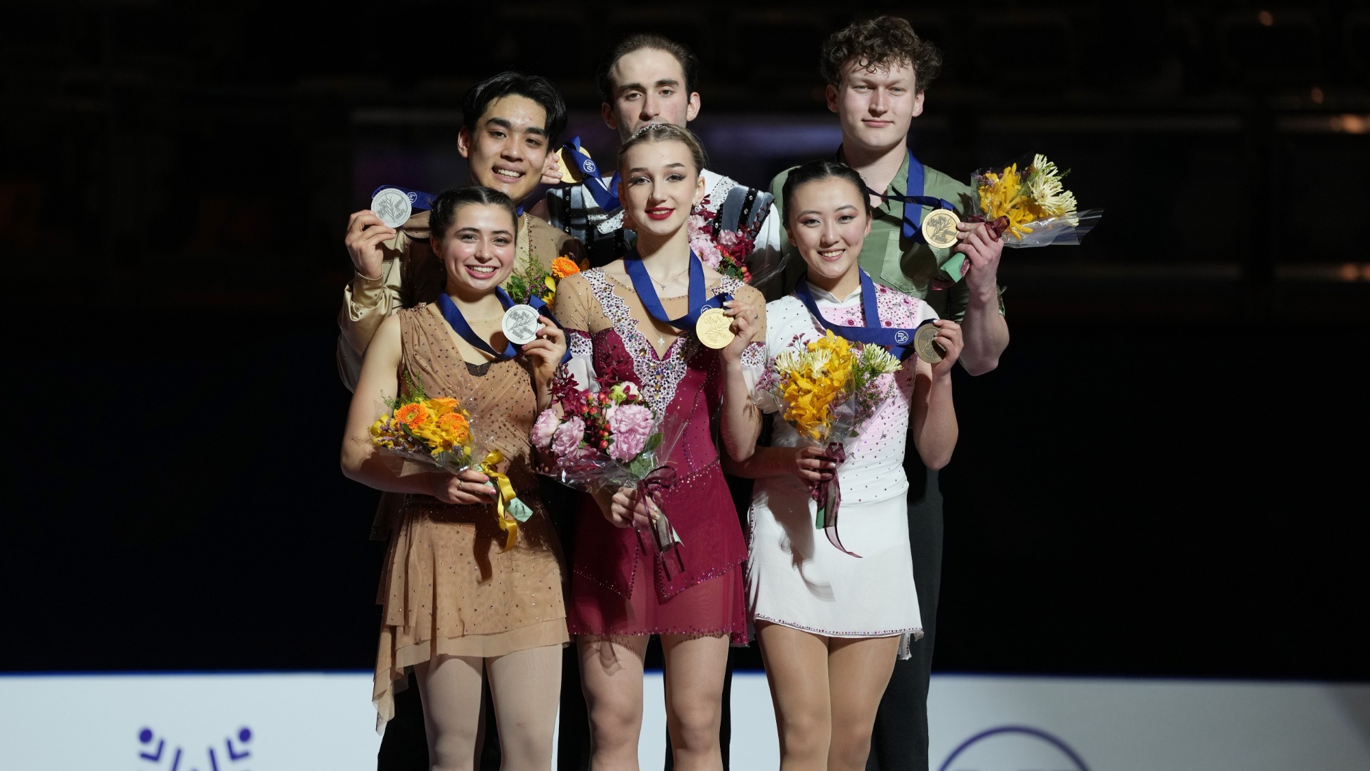 From left to right: silver medalists Olivia Flores and Luke Wang of United States, gold medalists Anastasiia Metelkina and Luka Berulava of Georgia and bronze medalists Naomi Williams and Lachlan Lewer of the United States pose on the podium with their medals at the medal ceremony after the Junior Pairs Free Skating during the ISU World Junior Figure Skating Championships