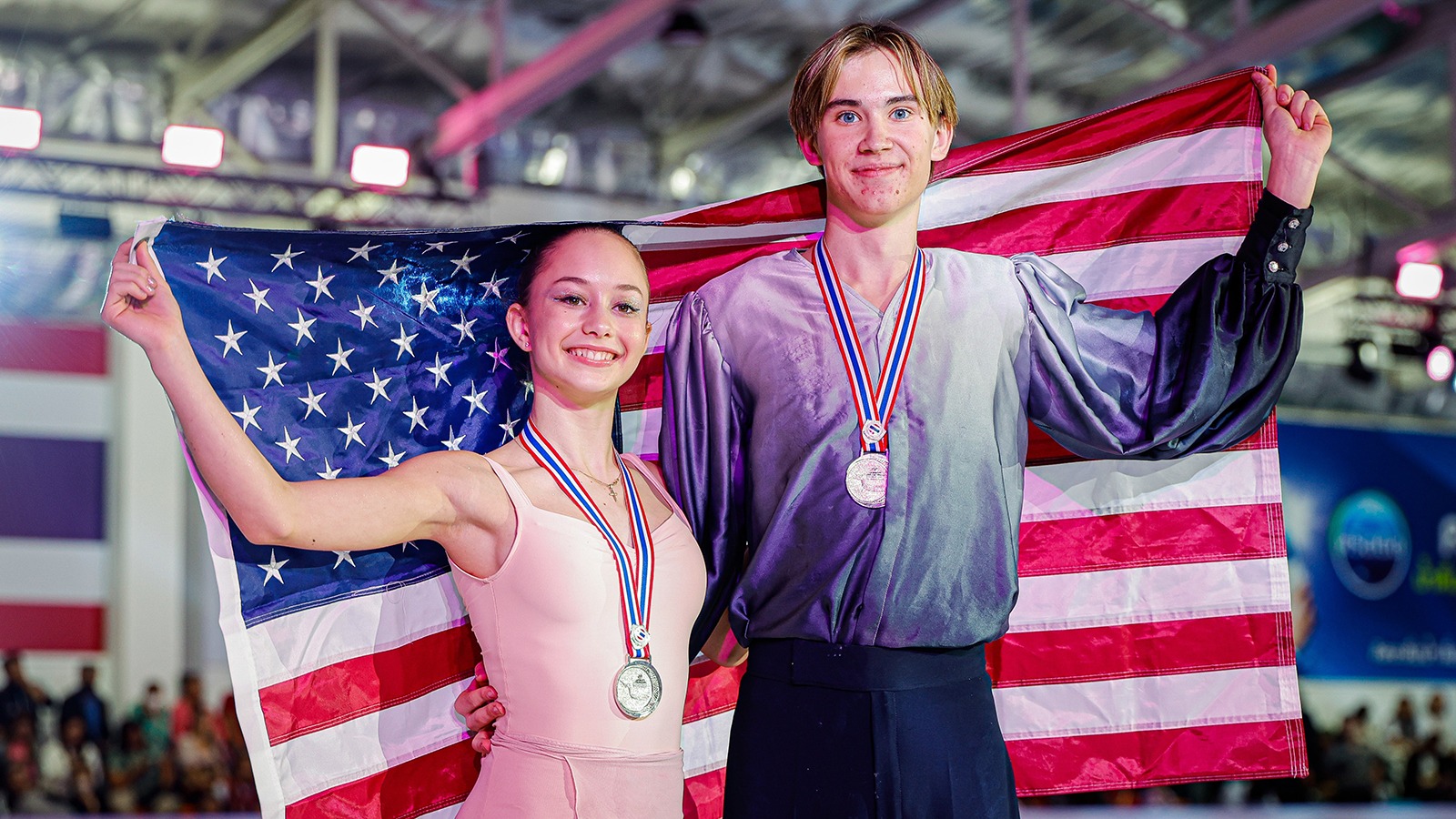 Draped in the American flag, the ice dance team of Hana Maria Aboian and Daniil Veselukhin showcase their silver medals.