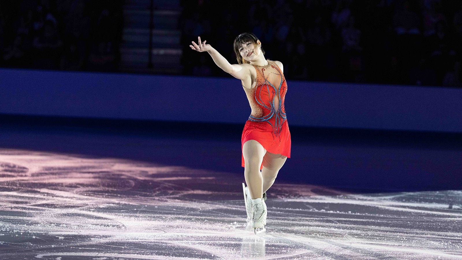 Dressed in red, arm extended, Alysa Liu performs at the Summer Sizzler in Boston.