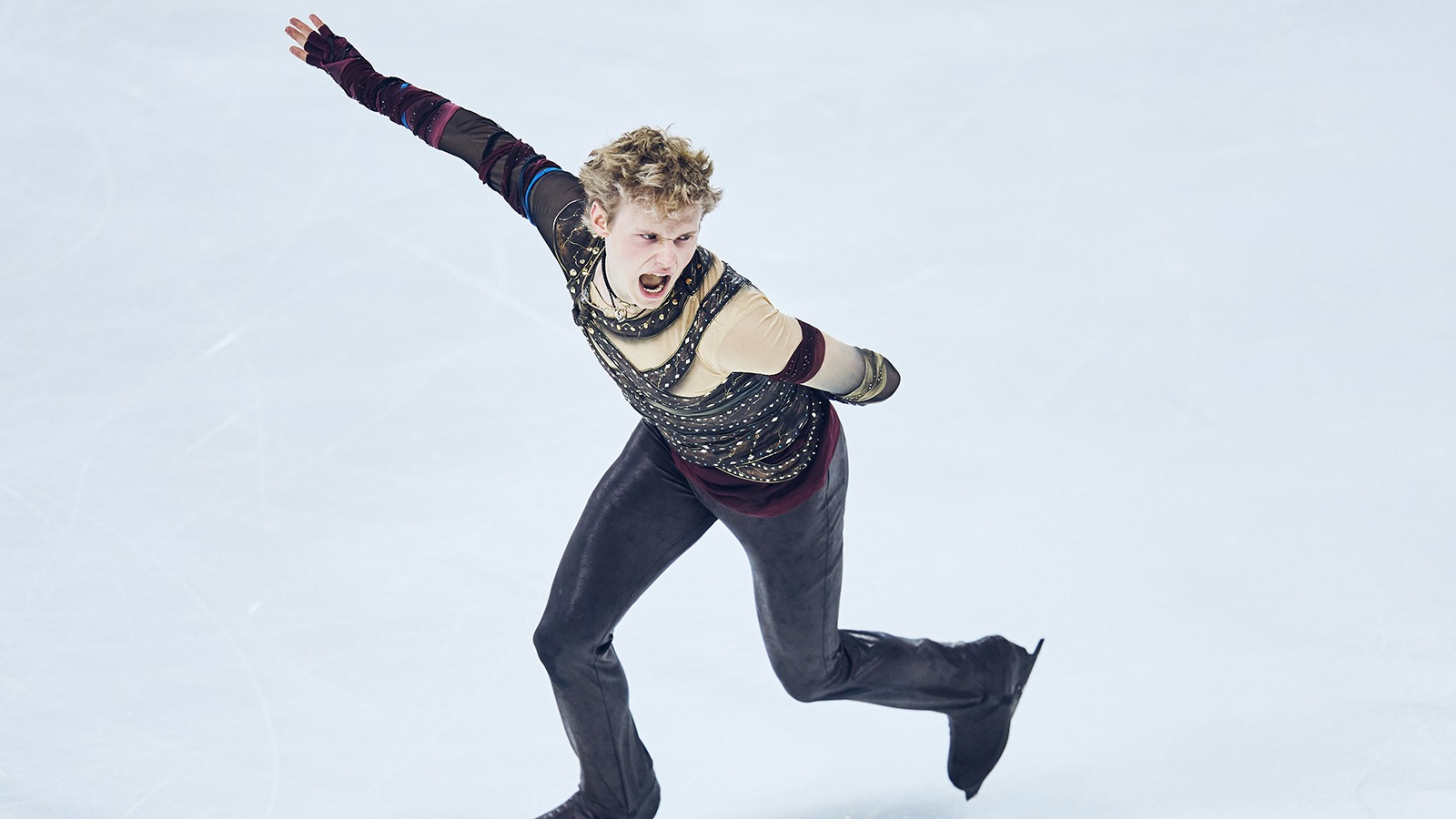 With a fierce face and one arm extended, Ilia Malinin performs his short program at Grand Prix de France