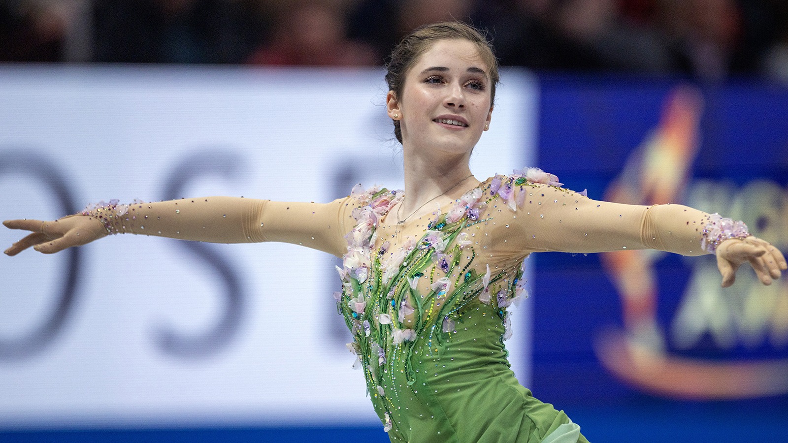 Isabeau Levito, wearing a green dress with arms extended, competes at 2025 World Championships.