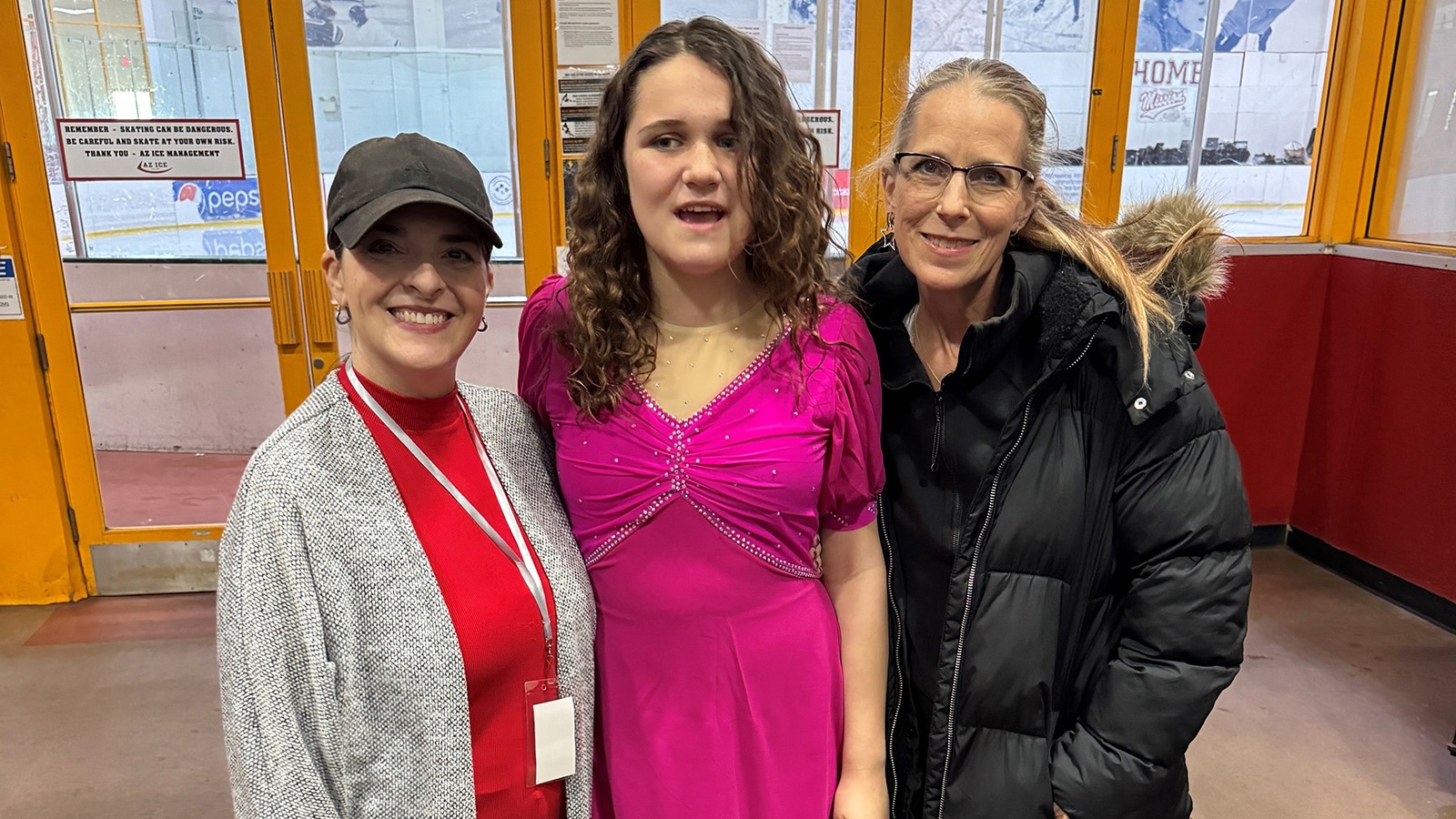 Lilly Gonzales, in a violet-color costume stands in the middle of her two coaches
