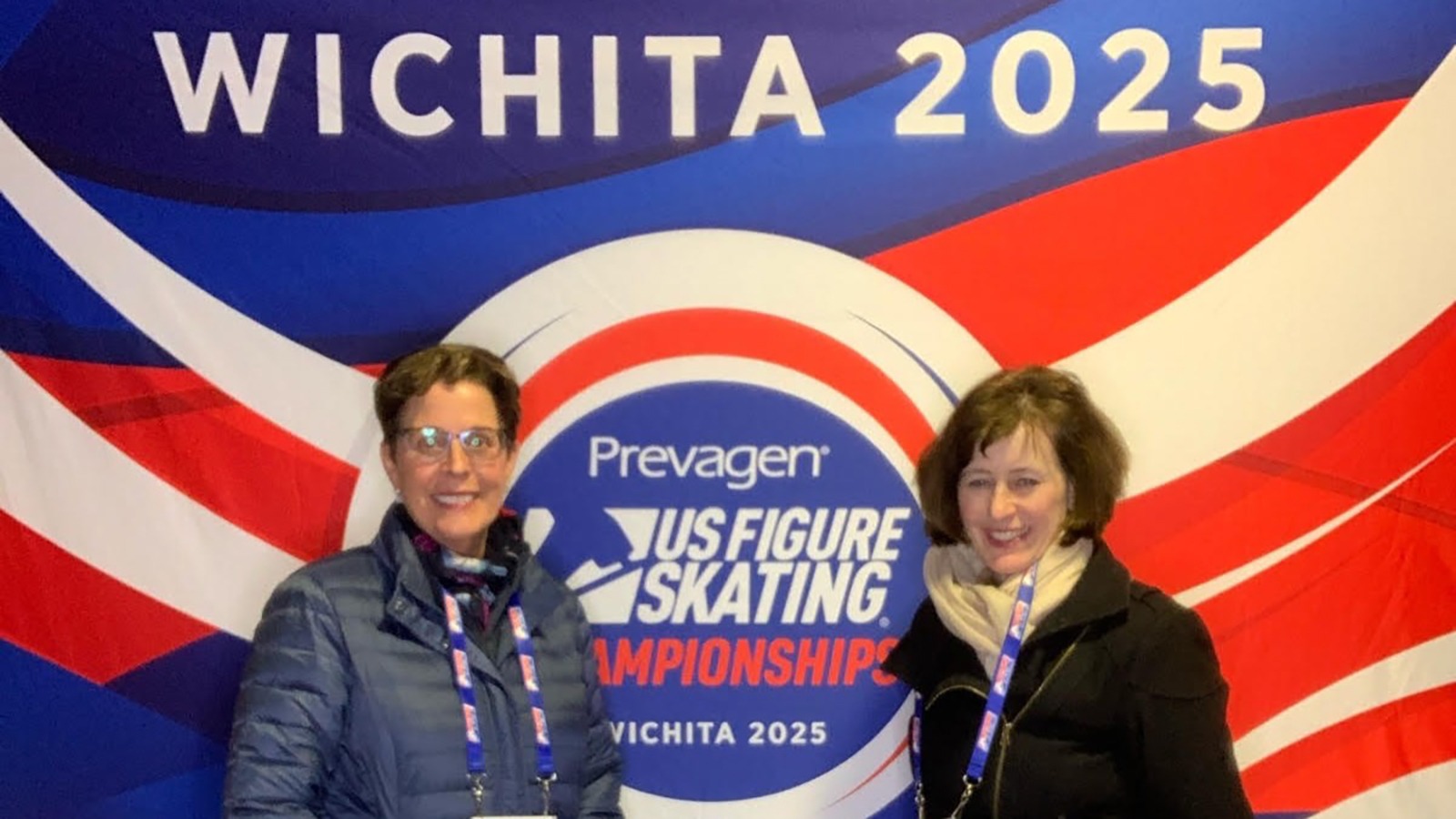 Loni Keenan and Kathleen Gazich stand in front of the red, white and blue banner for the U.S. Championships in Wichita.