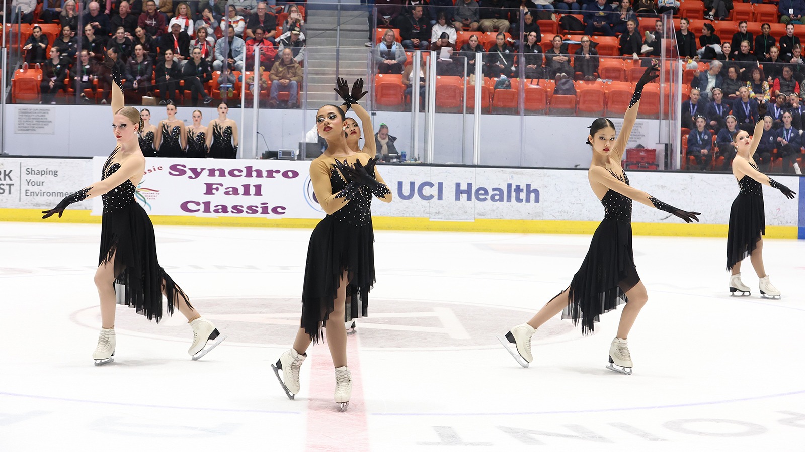Teams Elite junior, dressed in long black dresses, perform their 