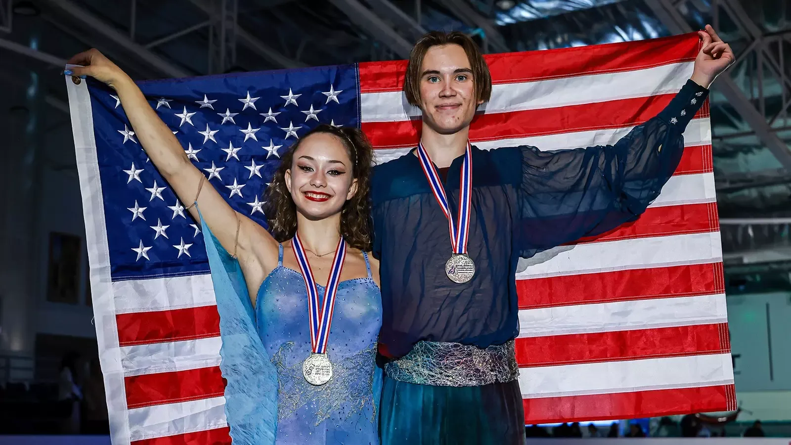 Hana Maria Aboian and Daniil Veselukhin hold up the American flag after receiving their gold medals at Junior Grand Prix Thailand