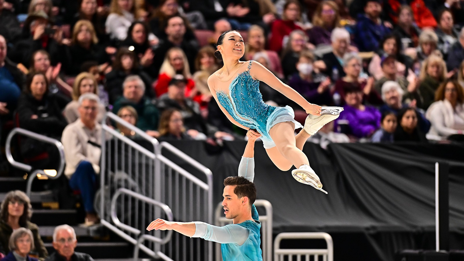 Audrey Shin, wearing a light green costume and a smile, is lifted by pairs partner Balazs Nagy at the 2025 U.S. Championships.
