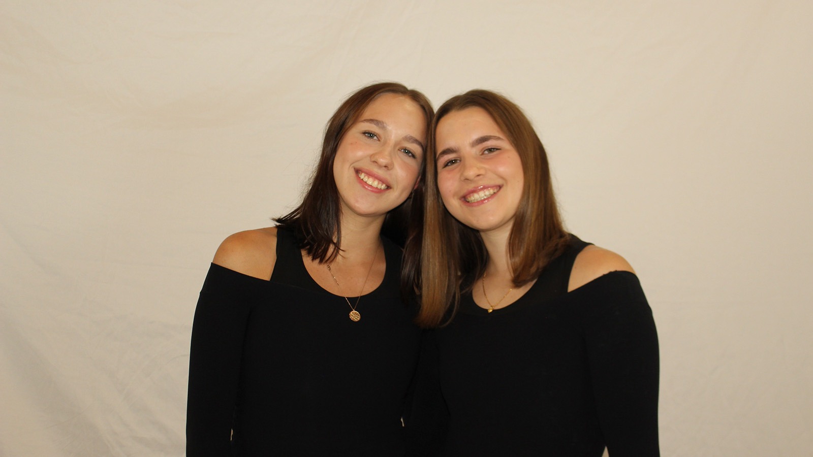Dressed in black, twins Sonia and Priyanka Lucey stand side by side
