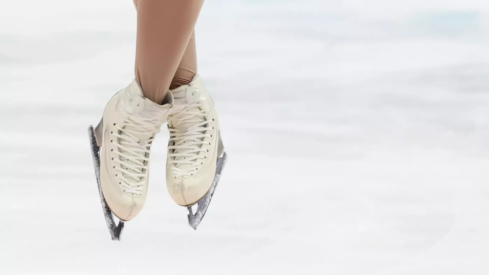 Close up image of a skater wearing white skates performing a jump