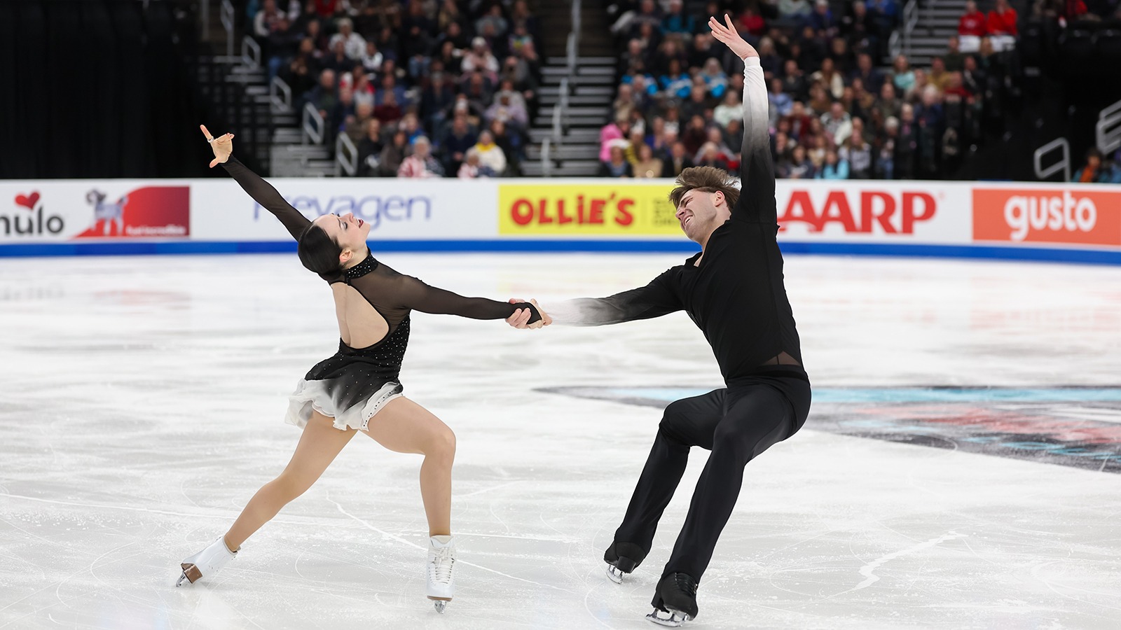 Katie McBeath and Daniil Parkman, holding hands, arch their backs in a graceful move