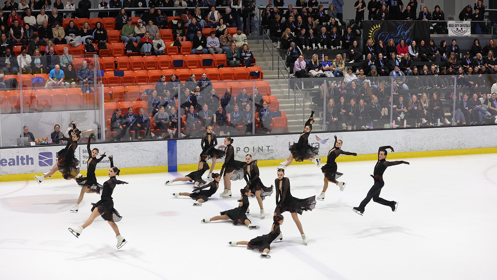 Teams Elite junior , dressed in black, perform an intricate pattern. 