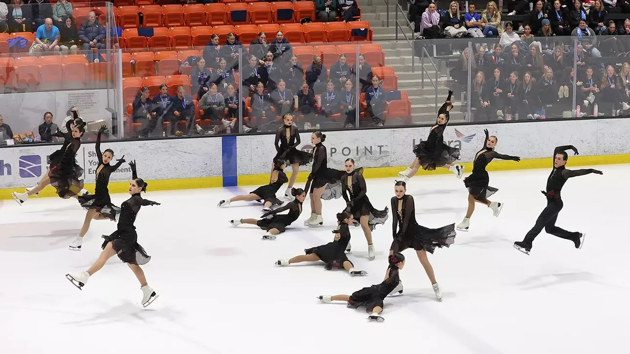 Teams Elite junior , dressed in black, perform an intricate pattern. 