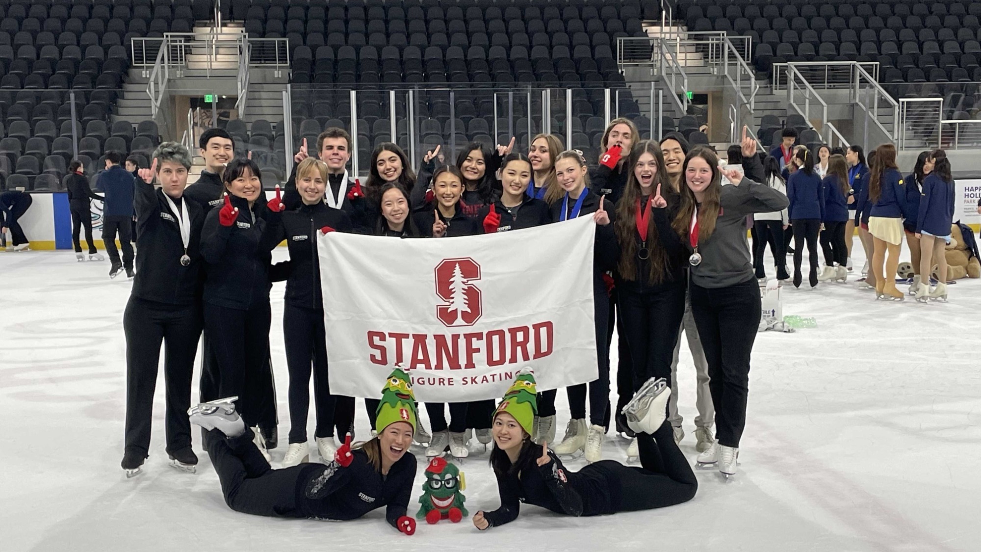 Stanford Figure Skating Members hold up their team flag after winning the Skates on the Bay competition in San Jose, California.