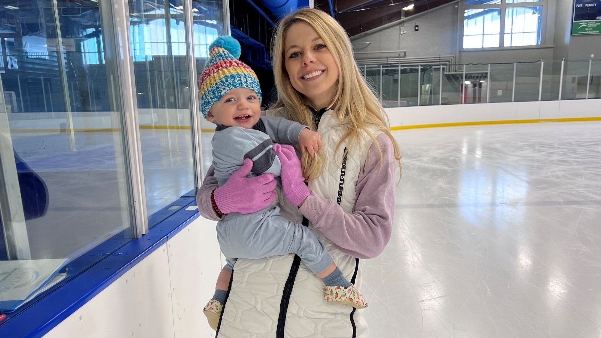 Alexa Knierim holds her smiling baby Braxton on the ice.