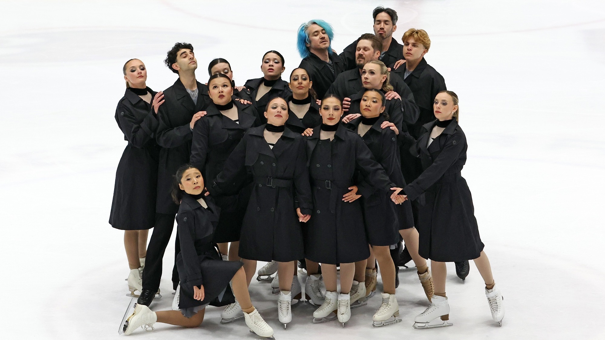 Forte of Boston's senior team, dressed in black, huddles closely in their free performance. 