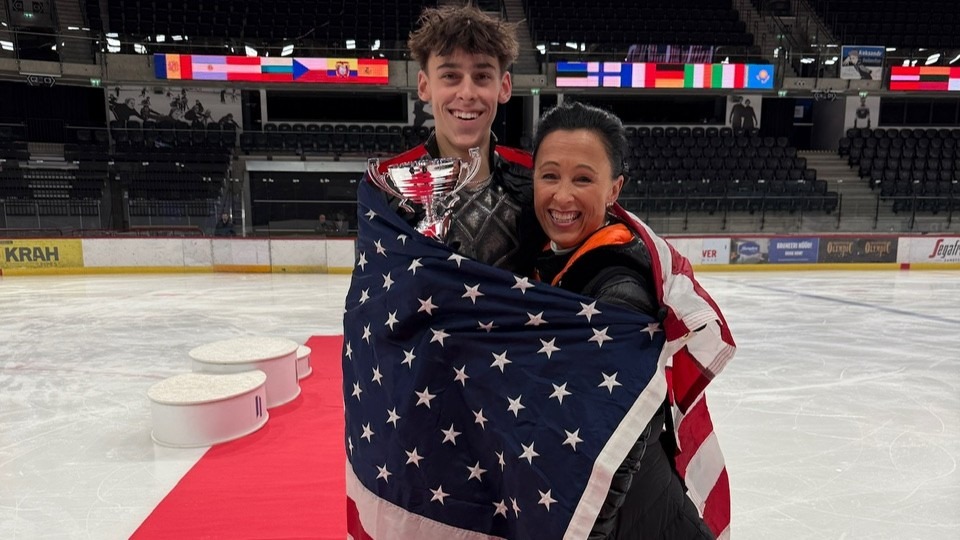 Patrick Blackwell and his mother and coach Annette Blackwell stand together with the U.S. flag draped around them at the Tallinn Trophy in Estonia. 