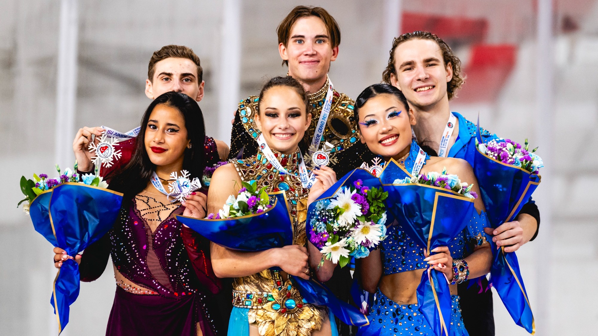 Hana Maria Aboian and Daniil Veselukhin and Effie Chen and Gordei Chitipakhovian stand on the podium with medals around their neck. They all hold bouquets of flowers with blue wrapping. 