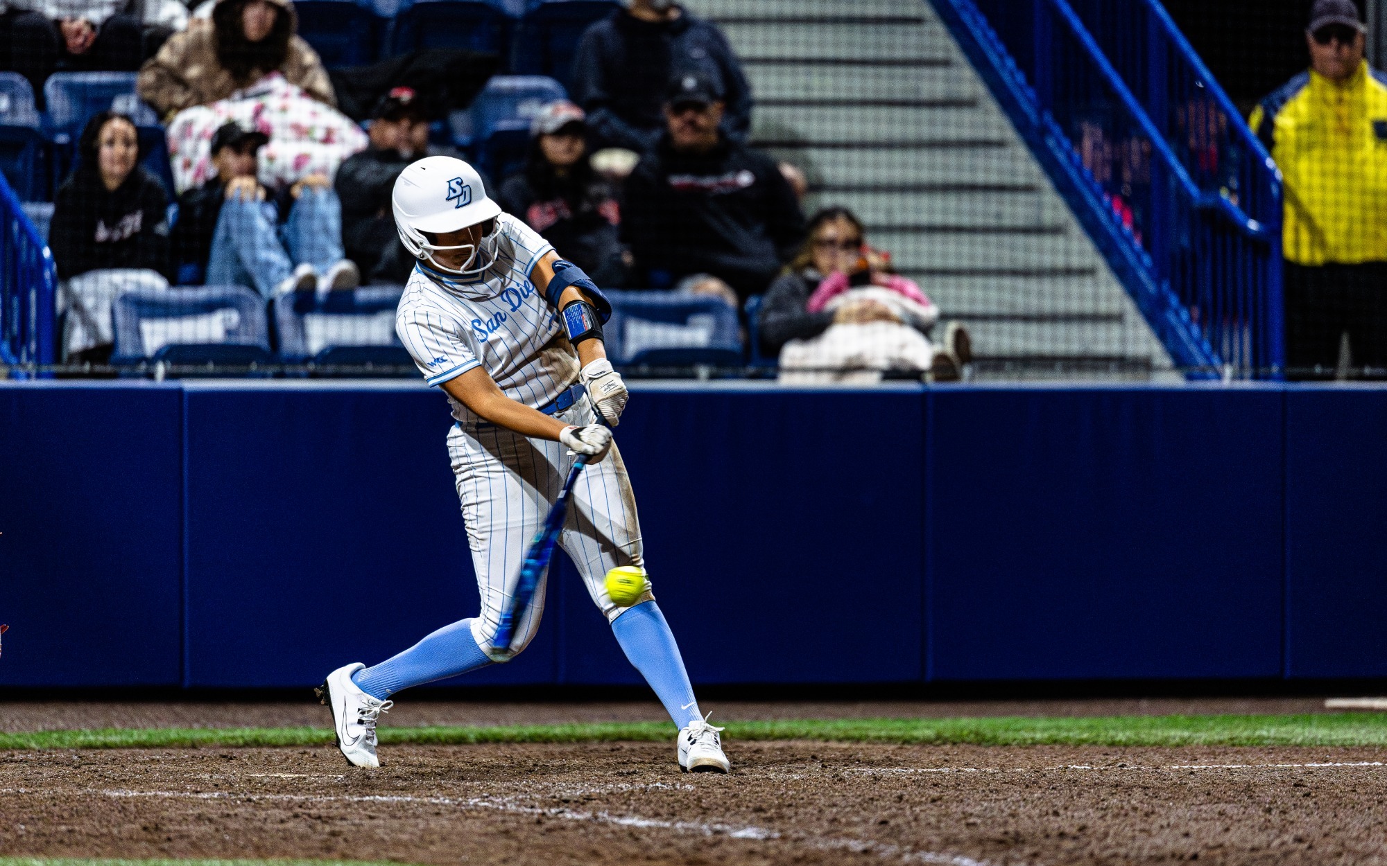 Softball player swinging bat