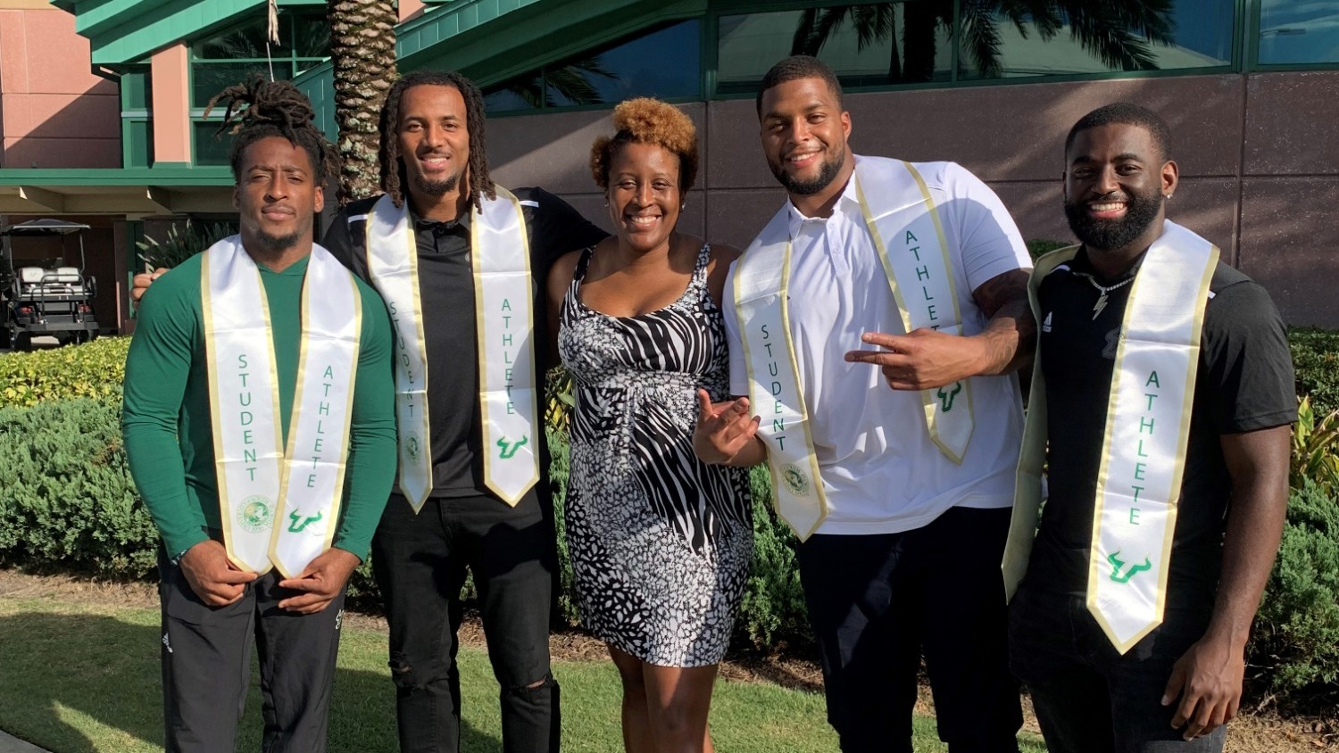 Kydani Dover with members of the football team following a graduation celebration.