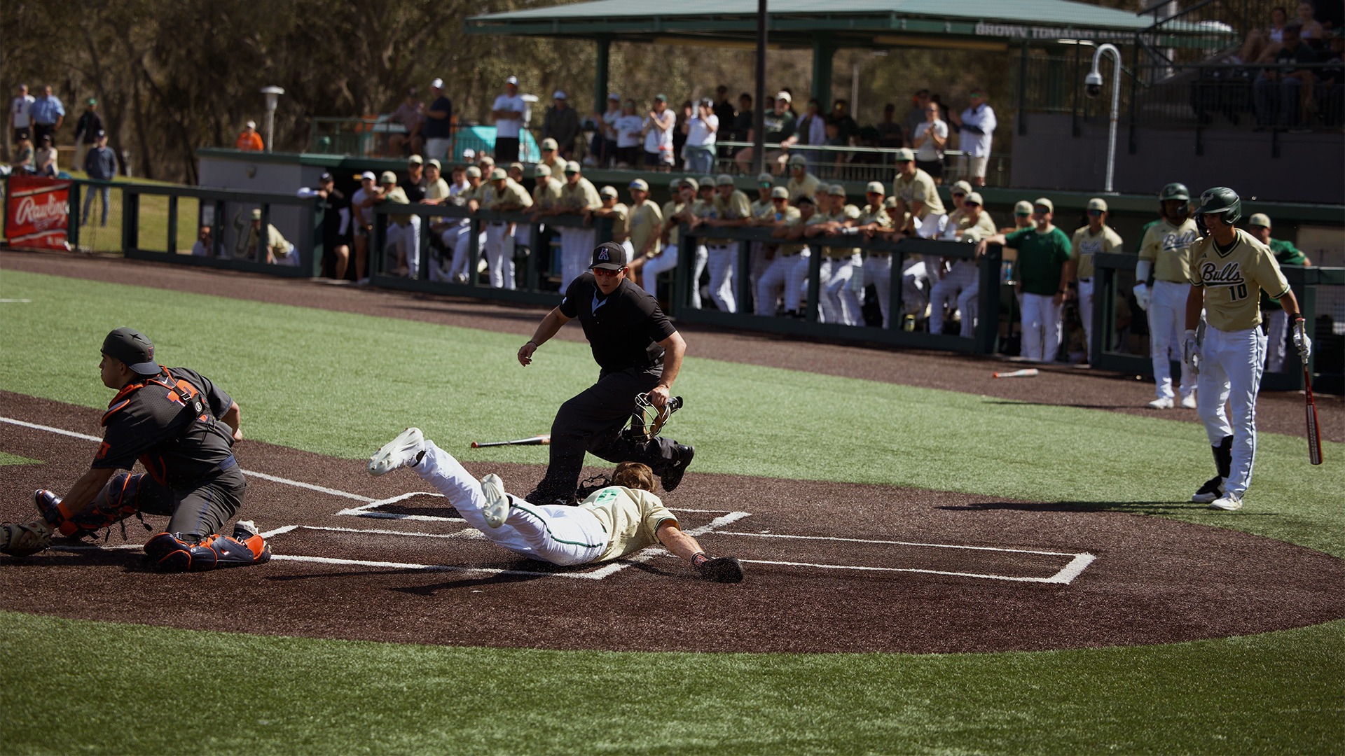 Eli Thomas sliding into home to score a run for the Bulls