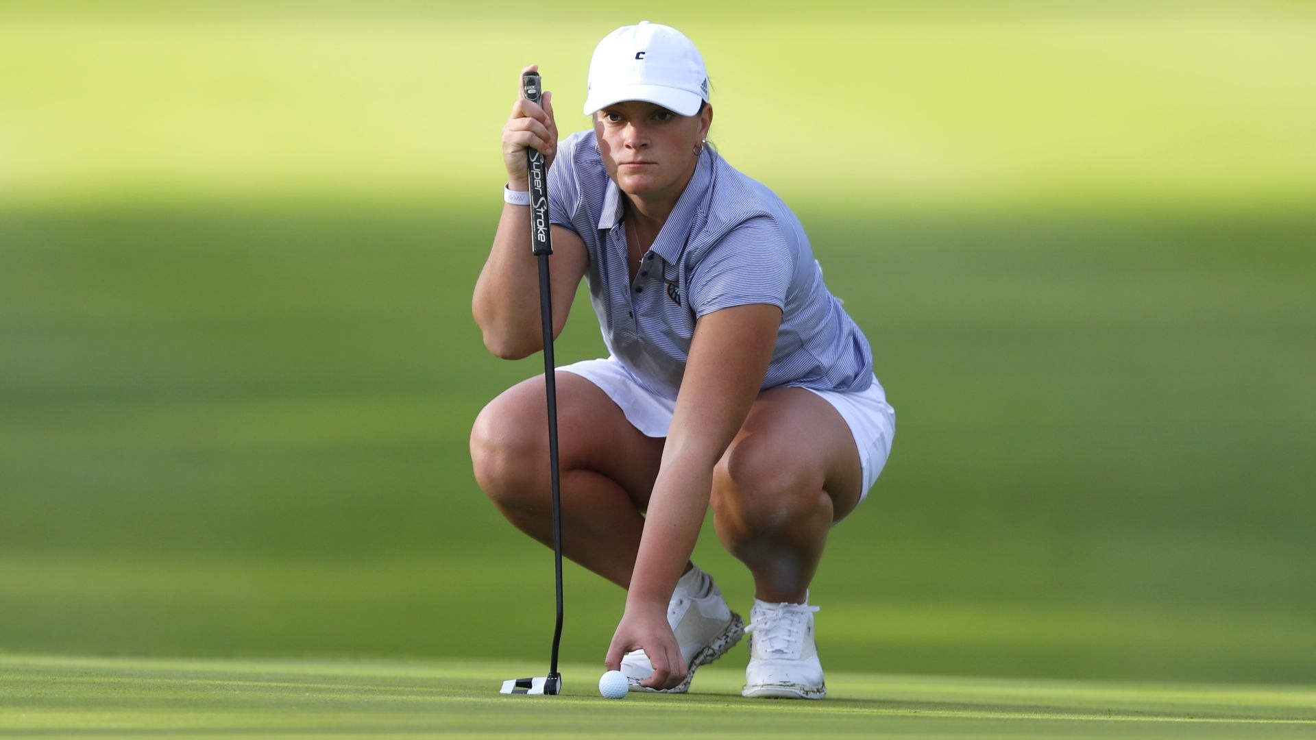 Bella Bugg picks up her ball marker as she takes a final read on her putt