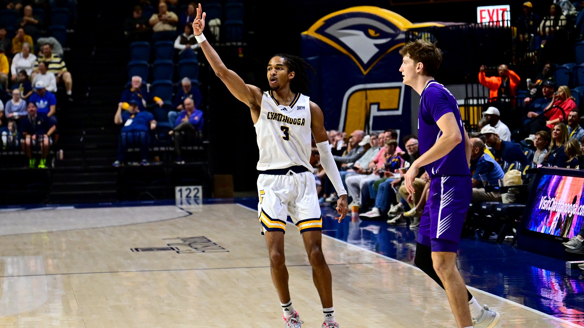 Jikari Johnson holds 3 fingers in the air after hitting a three vs Furman