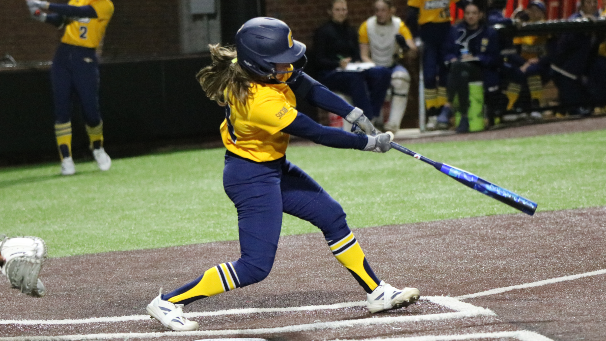 Softball player hitting the ball in a game.
