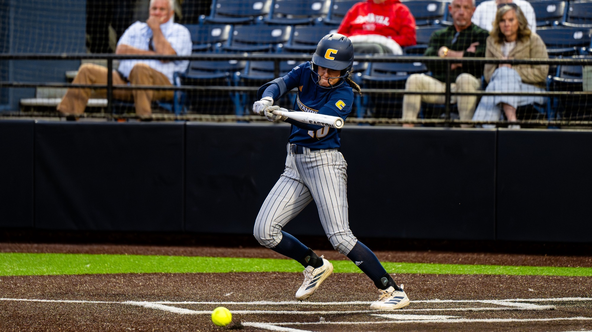 Softball player hitting the ball from the left side of the plate.