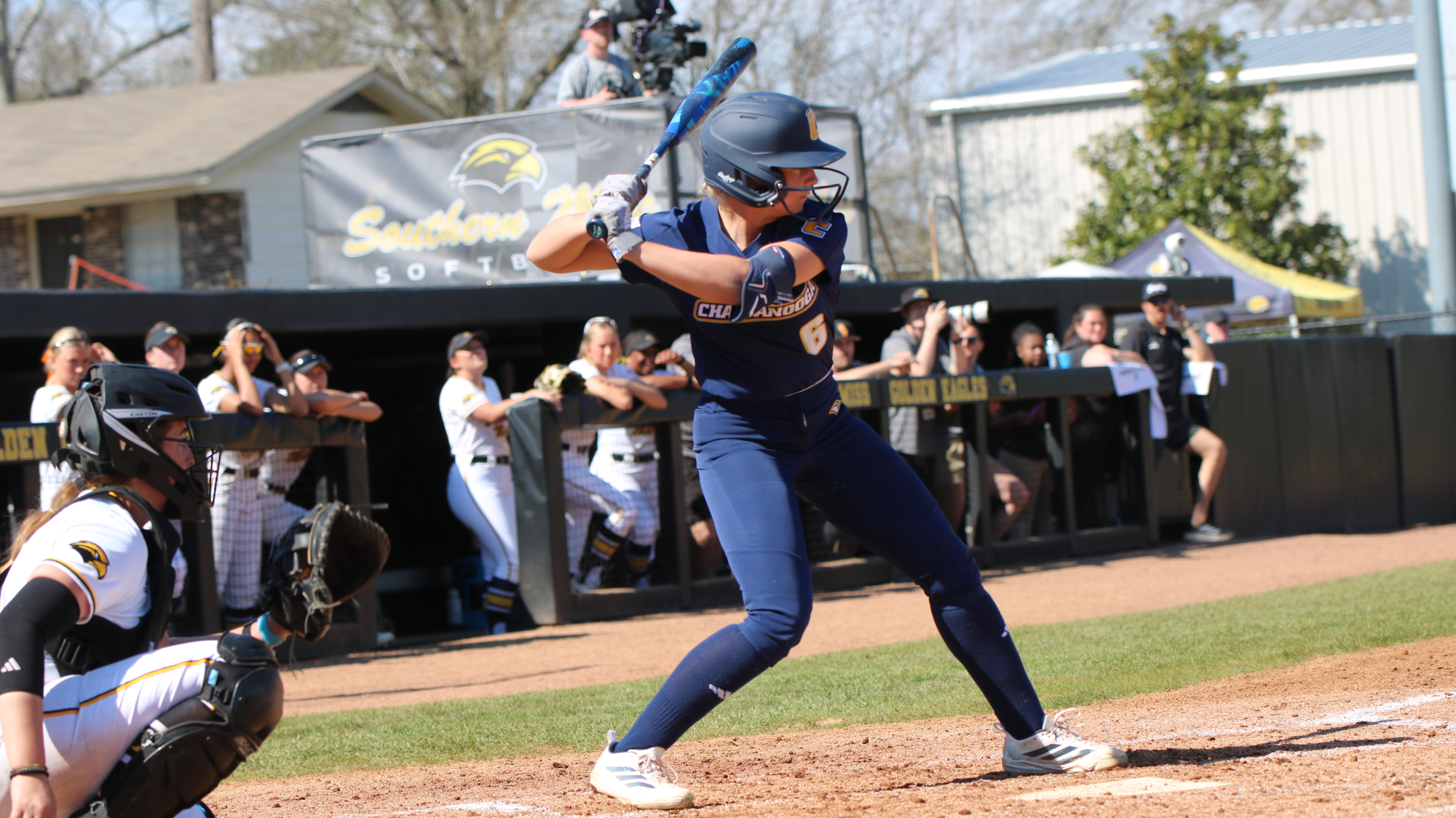 A softball player at the plate waiting for the pitch.