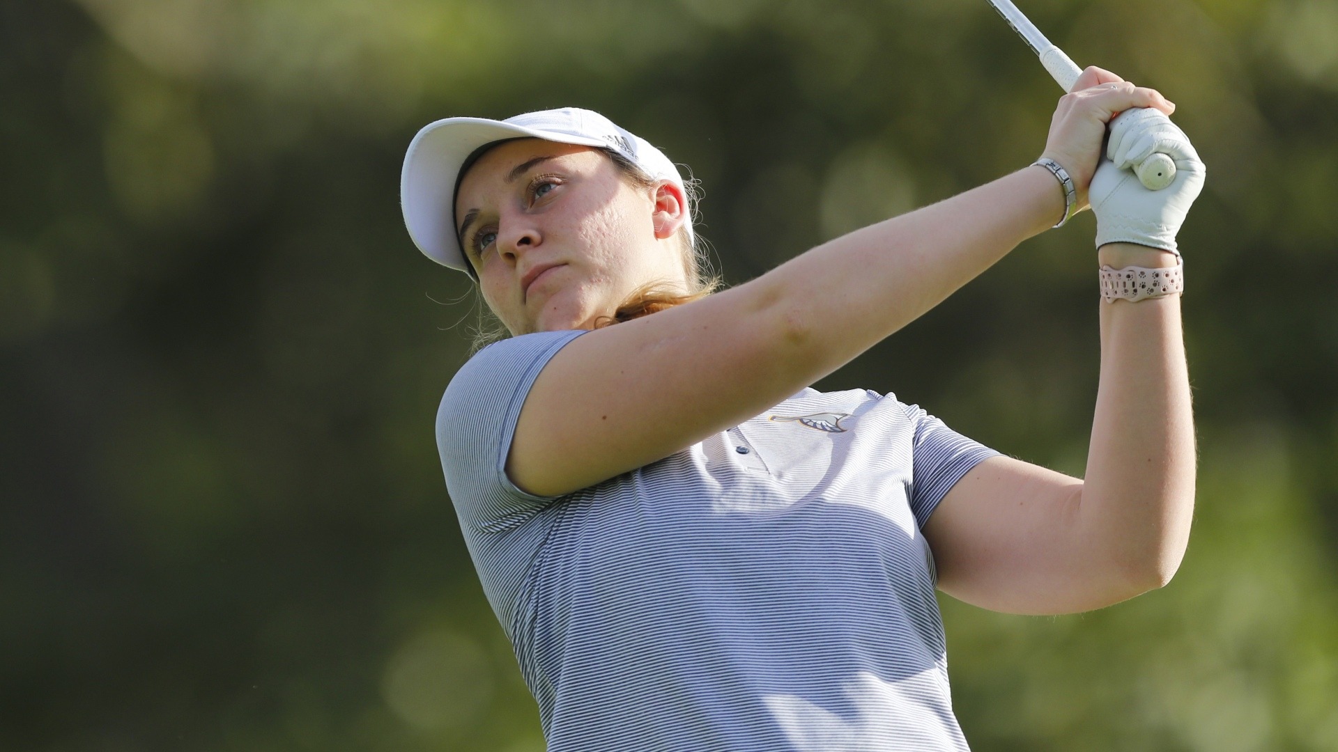 Makenzie Cooper stares at her ball flight as her swing clears her shoulders