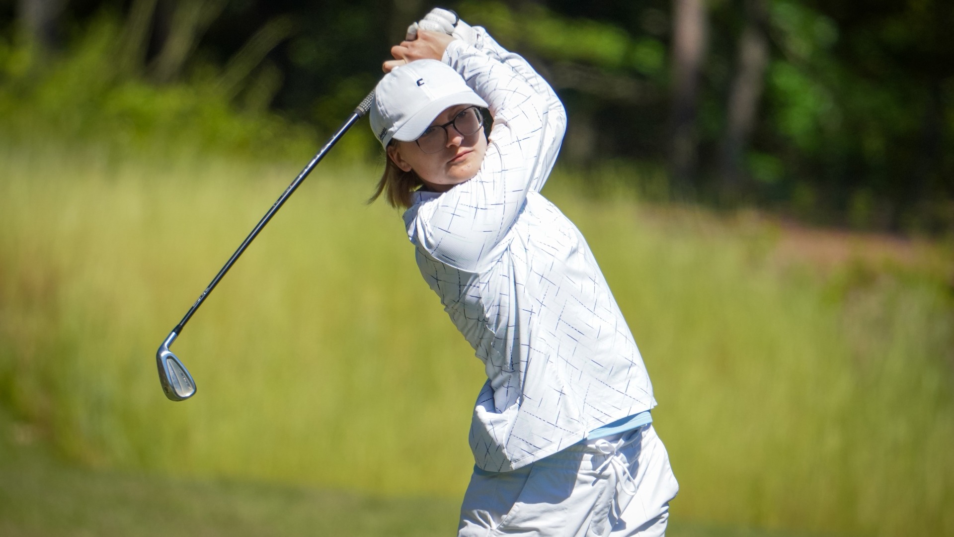 Rugile Pauliukonyte stares at her ball flight to the green as she completes her swing.