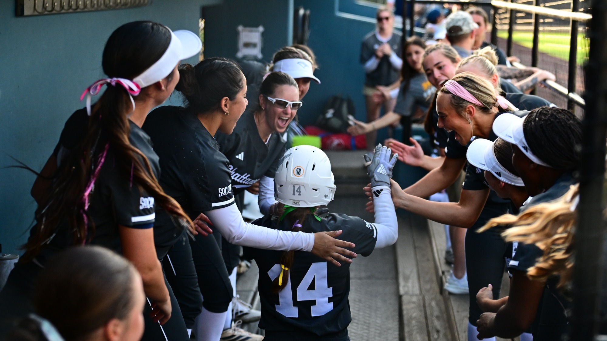 A softball player is congratulated in the dugout after driving in the walk-off winning run.
