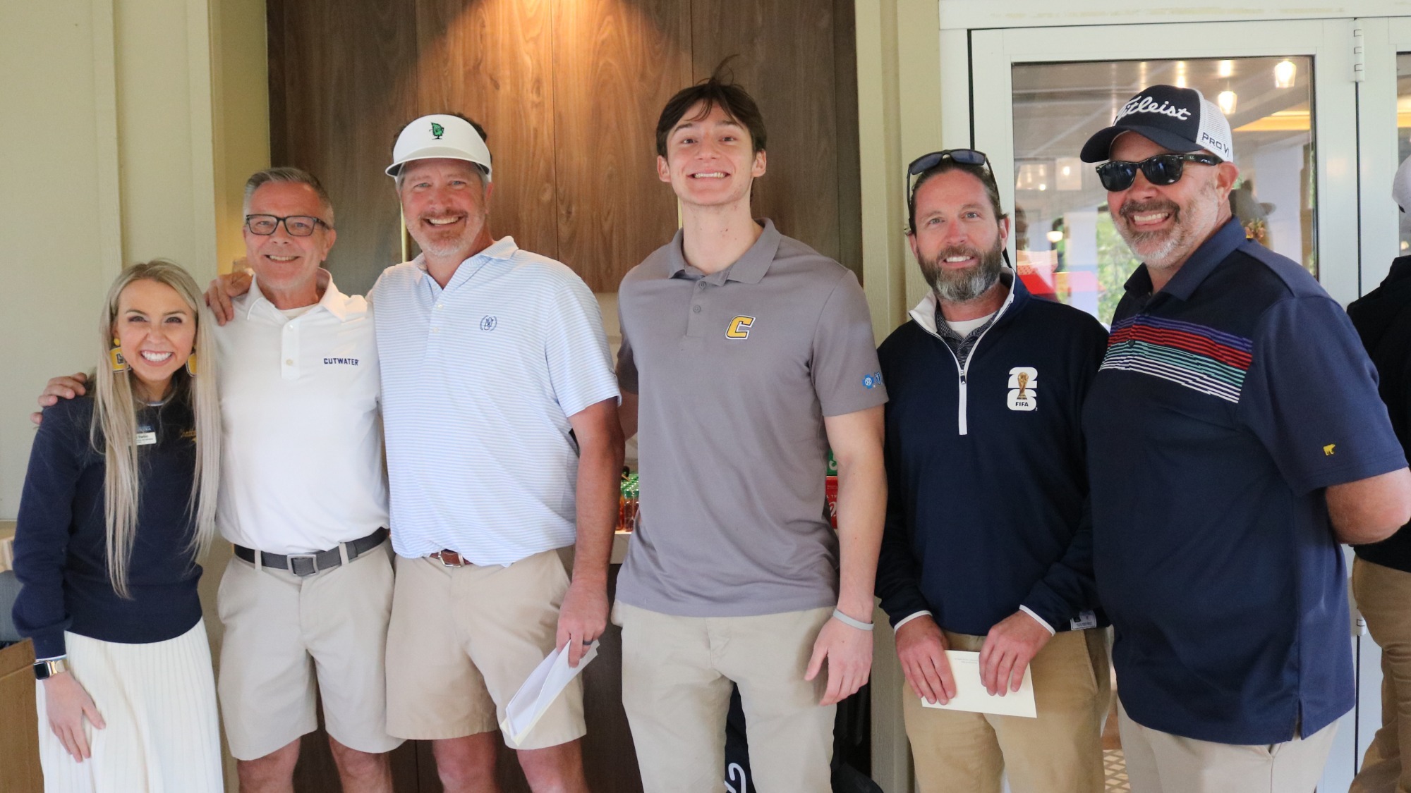 A group of golfers pose with their prize after winning their flight.