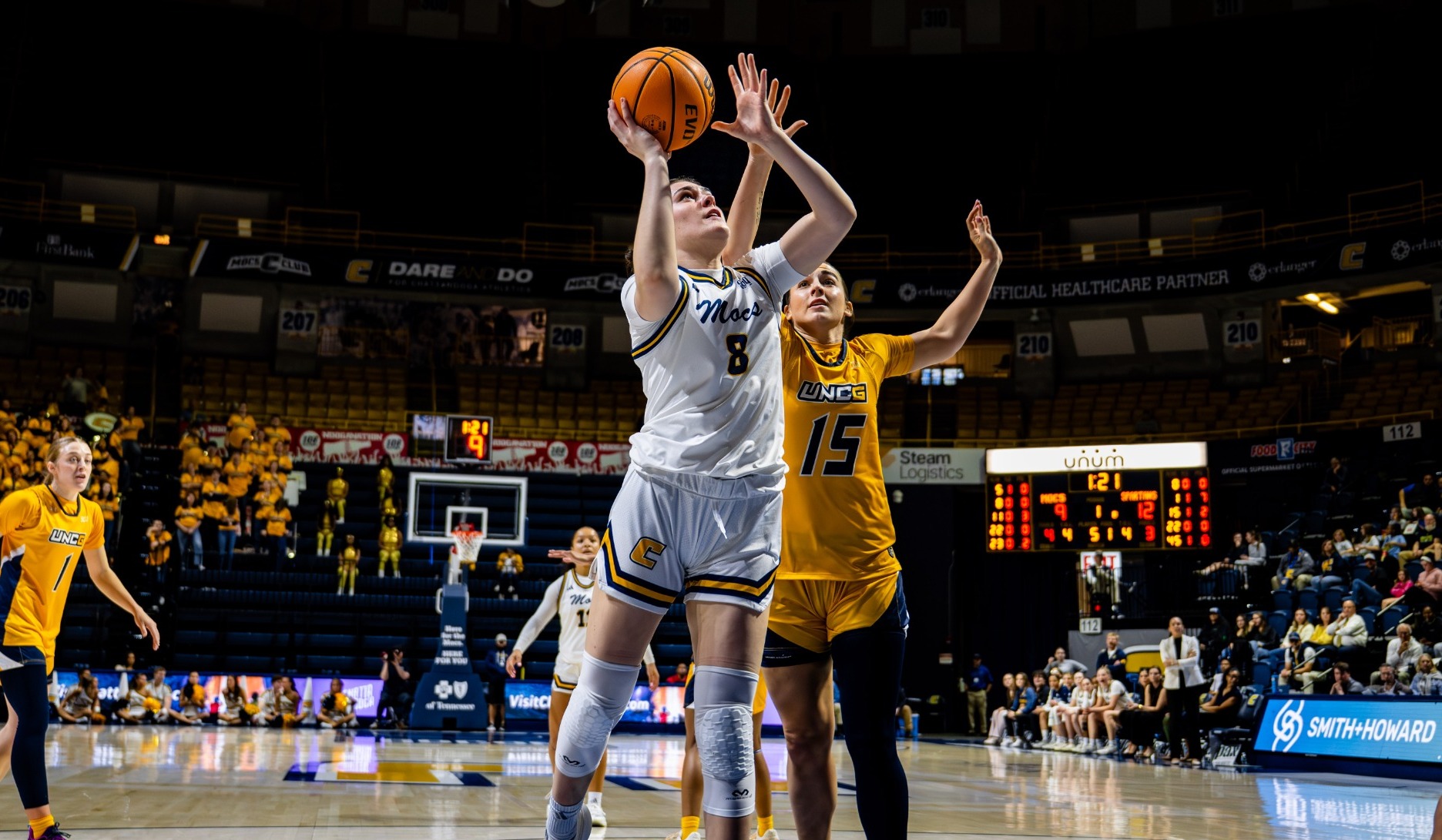 Evie Bruce driving to the basket at home against UNCG